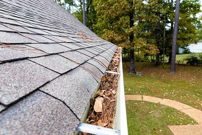 close up of clogged gutters being cleared out